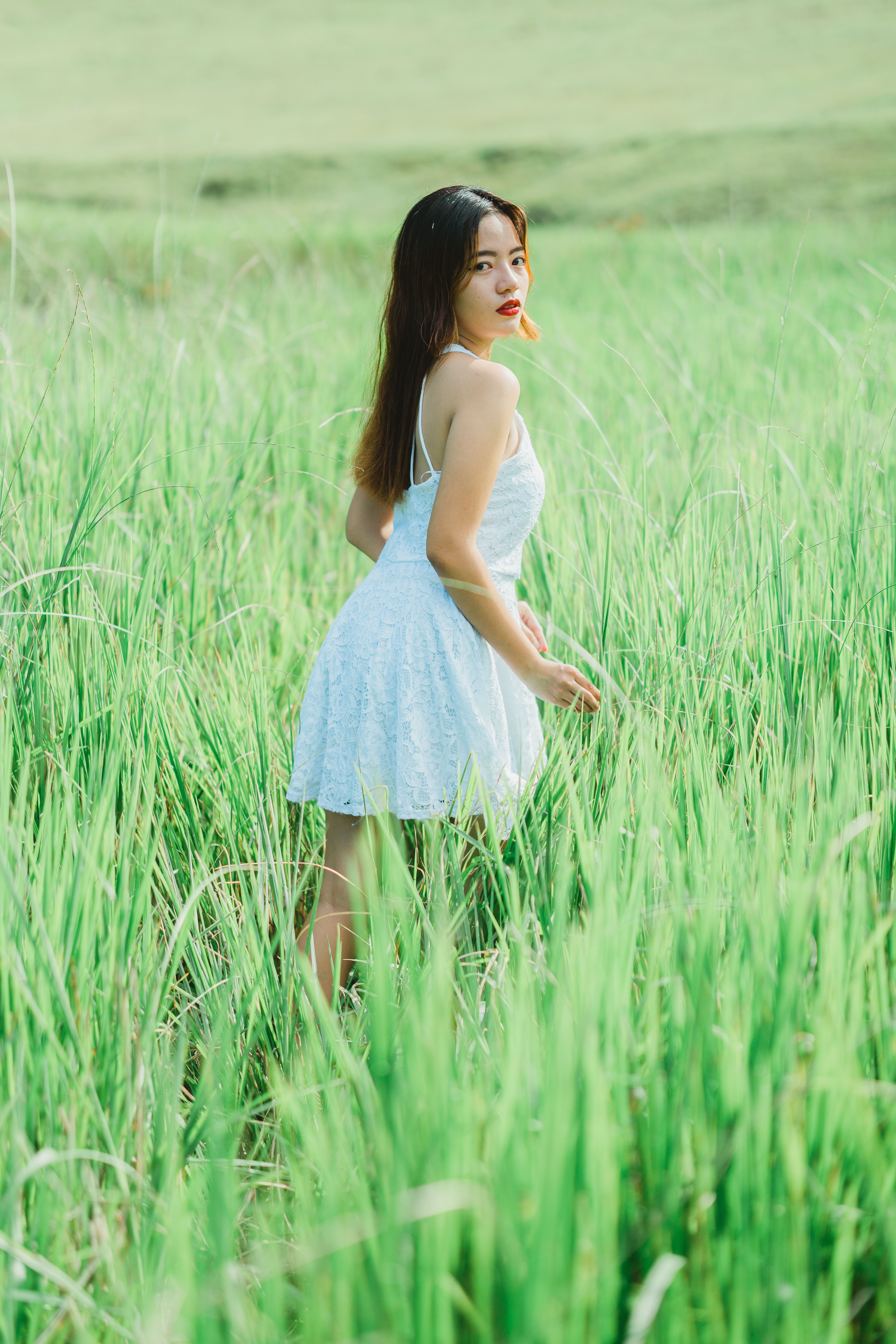 A Woman in White Dress Standing on Green Grass Field · Free Stock Photo