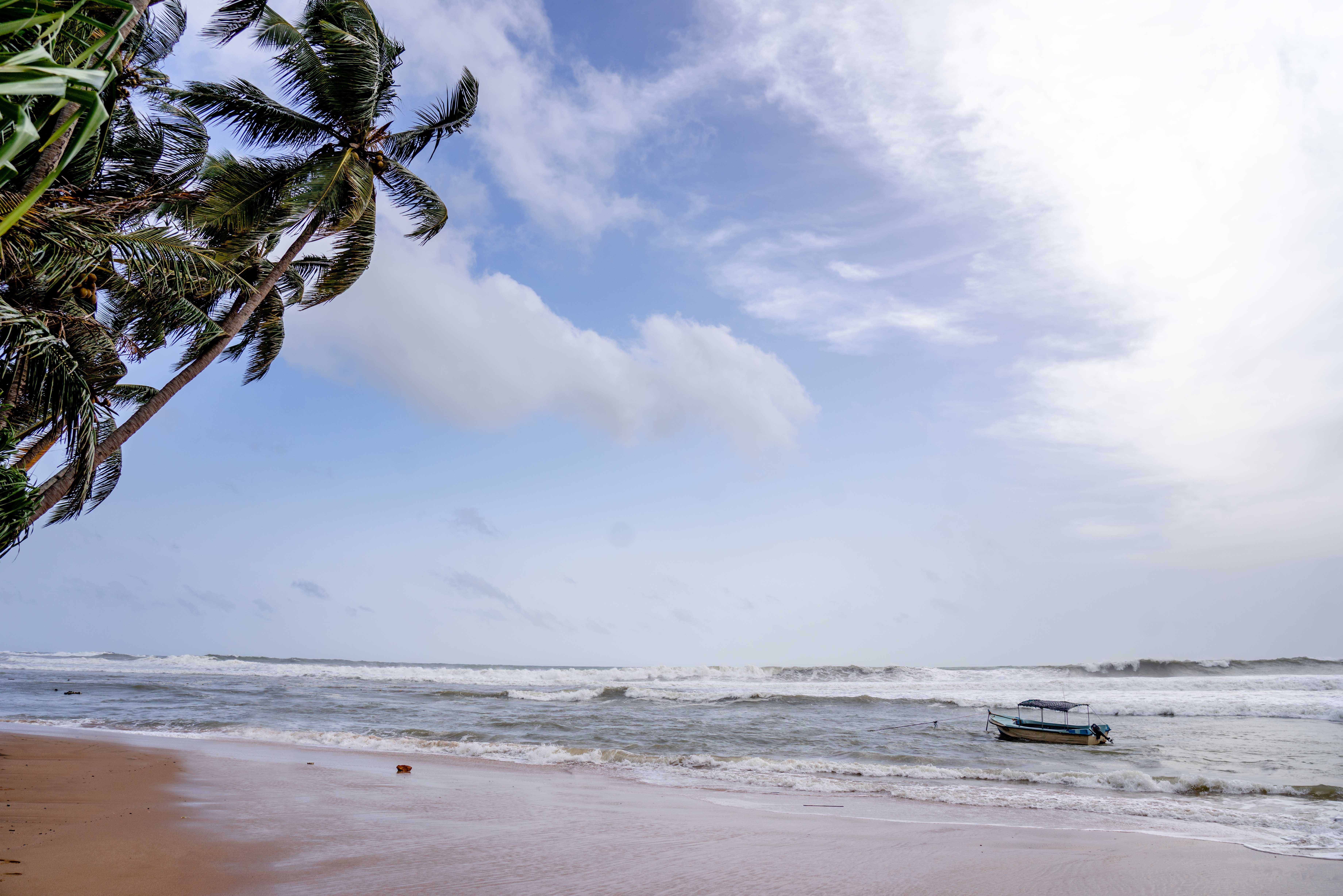 A Boat on the Sea Under the Blue Sky and White Clouds · Free Stock Photo