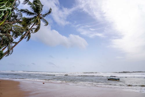 A Boat on the Sea Under the Blue Sky and White Clouds