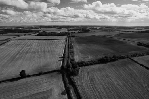 Black and white aerial view of rural fields and roads in England's countryside.