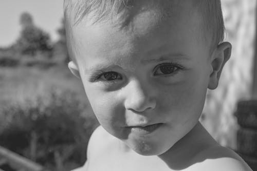 A Grayscale Photo of a Young Boy with a Beautiful Eyes
