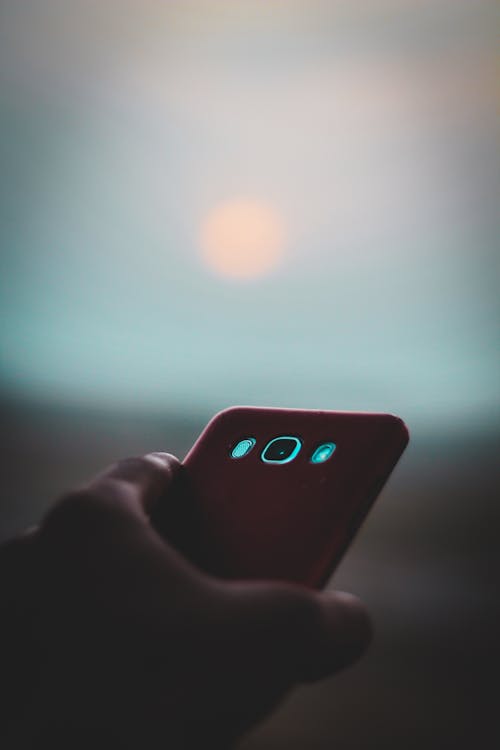 Gratis Orang Memegang Smartphone Android Samsung Putih Dengan Case Merah Foto Stok