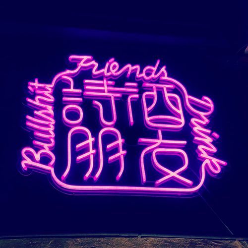 Free Bright neon sign displaying English and Chinese text, perfect for night-time decoration concepts. Stock Photo