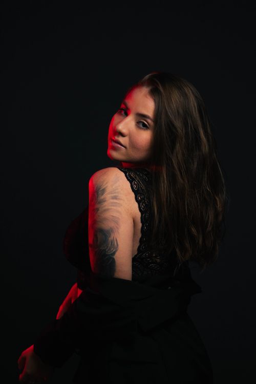 Free Artistic portrait of a woman with tattoo in dramatic lighting, emphasizing elegance and mystery. Stock Photo