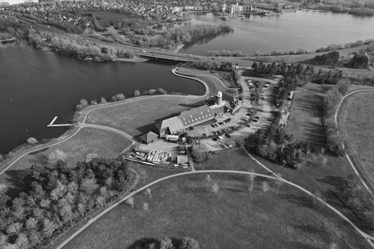 Aerial shot of Caldecotte Lake, Milton Keynes, showcasing surrounding landscapes in black and white.
