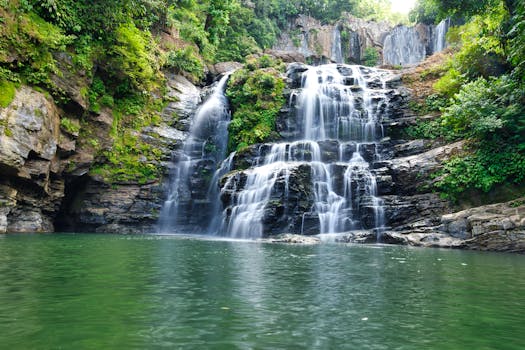 Beautiful Ojochal waterfall cascading into a lush green pool in Costa Rica.