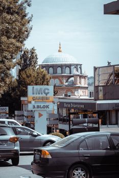 Cars on an Istanbul street with a historical domed building in the background.