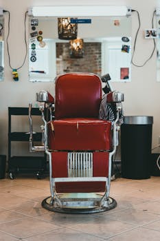 Classic red barber chair in a retro-style barbershop interior with mirrors.