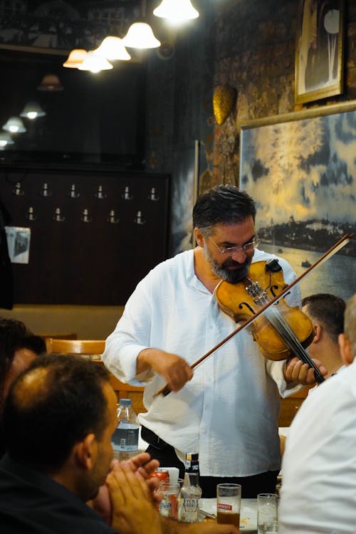 A Man in White Long Sleeves Playing Violin