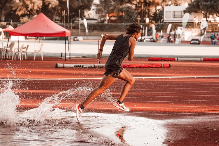 Man Running Through Puddle On Track