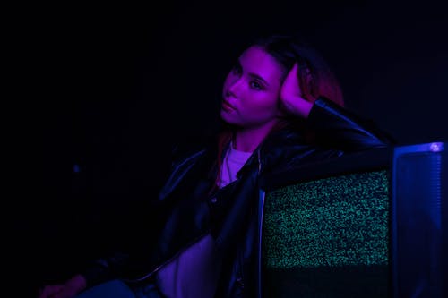 Free Woman in Black Leather Jacket Leaning on Chair Stock Photo