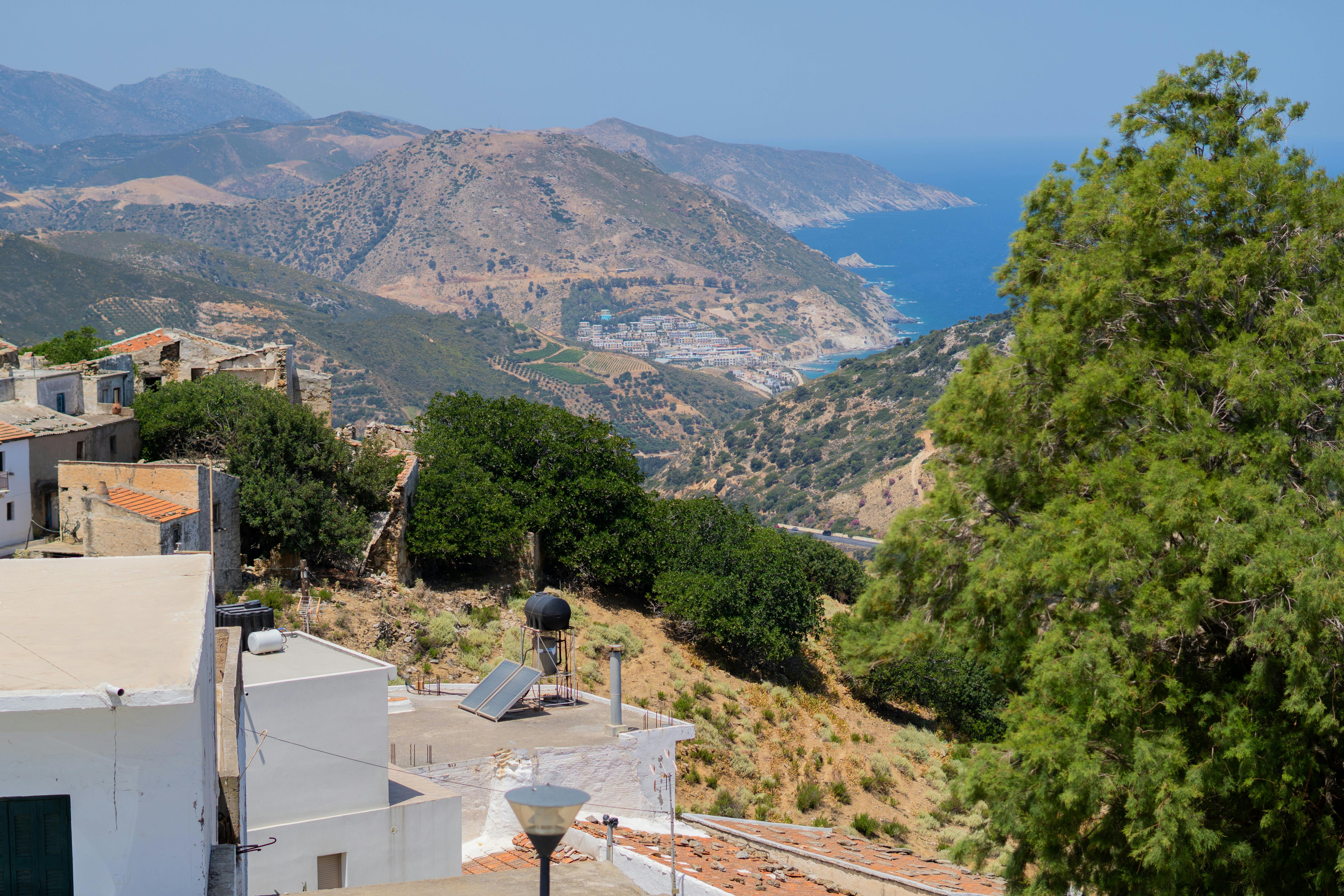 Breathtaking view of Mediterranean coastal hills and traditional houses under blue skies.