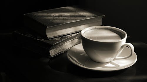 Free Coffee Cup Next To Stack Of Books Stock Photo