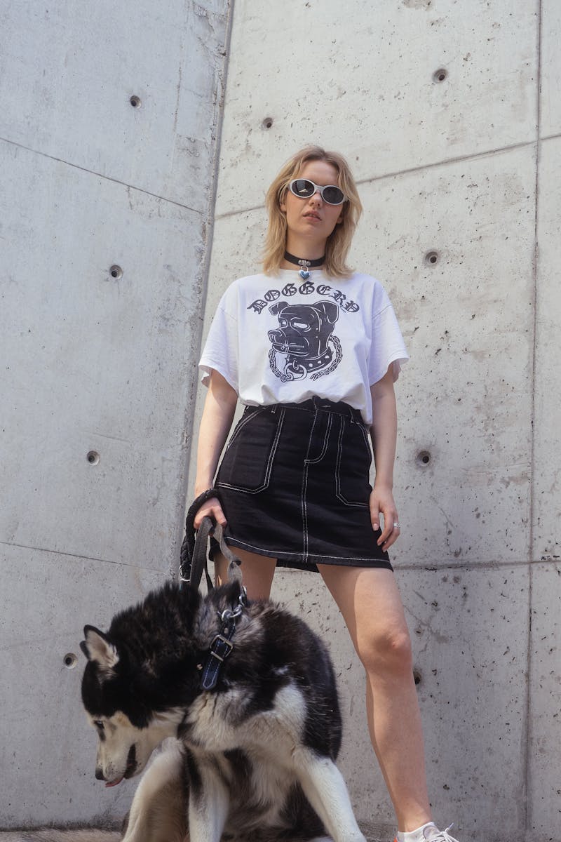 Woman Wearing a White Shirt and Denim Skirt Posing with a Dog