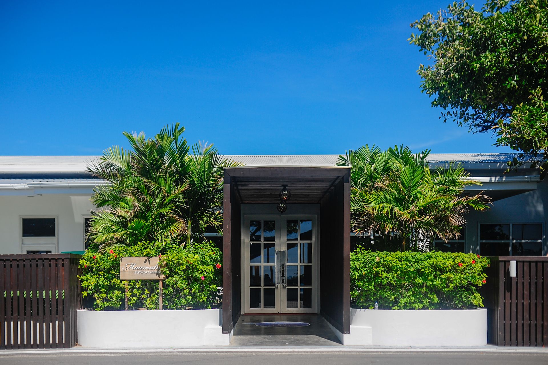 Luxurious modern house entrance surrounded by tropical plants in Malé, Maldives.