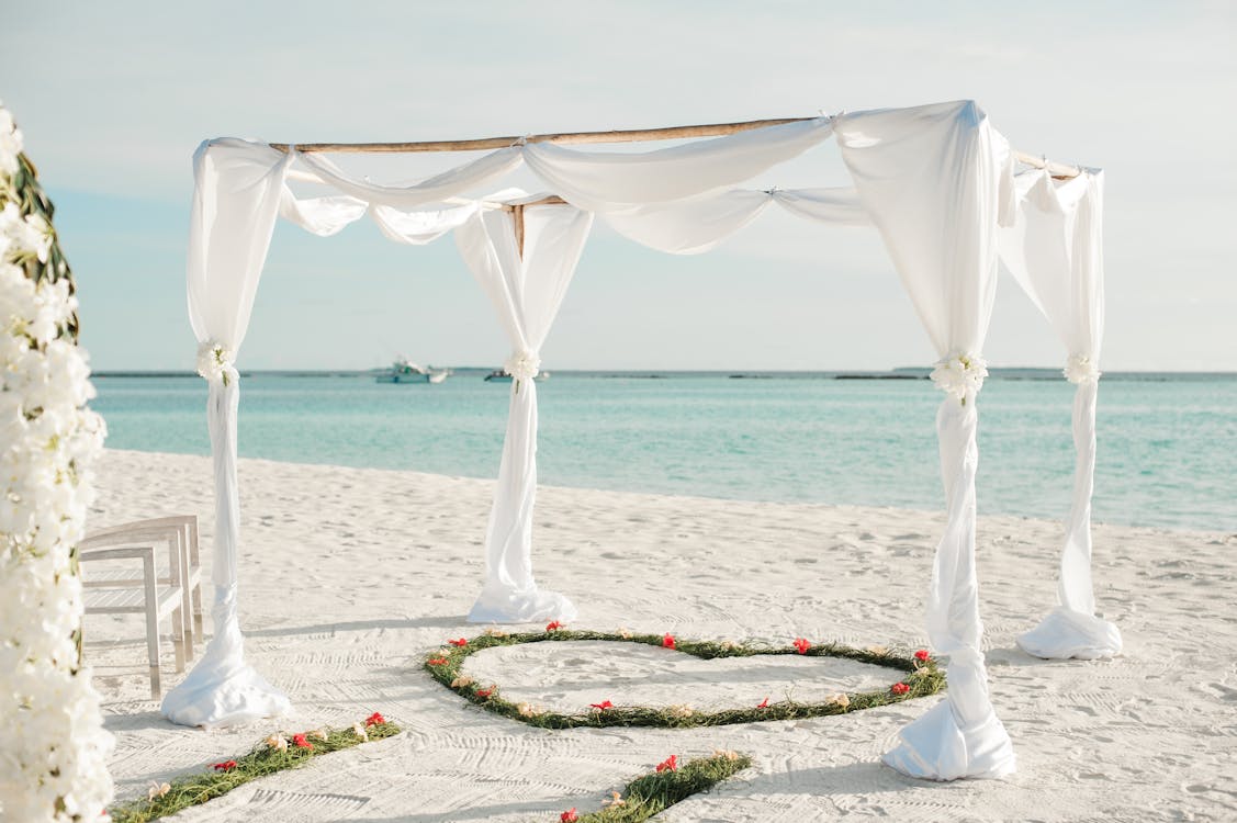 Free White Fabric Canopy Tent With Green Heart Floor Decor at Beach Stock Photo