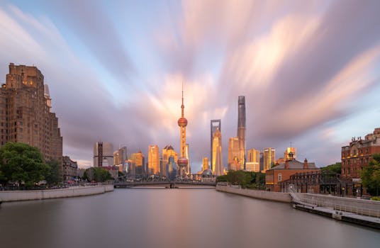 Stunning Shanghai skyline featuring the Oriental Pearl Tower and skyscrapers at sunset with dramatic clouds.