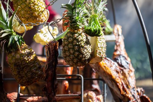 Free Close-up of pineapples and meat grilling on a barbecue under a sunny sky. Stock Photo