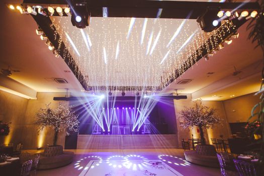 Interior of an upscale event venue with decorative lighting and empty seating area, perfect for weddings or parties.