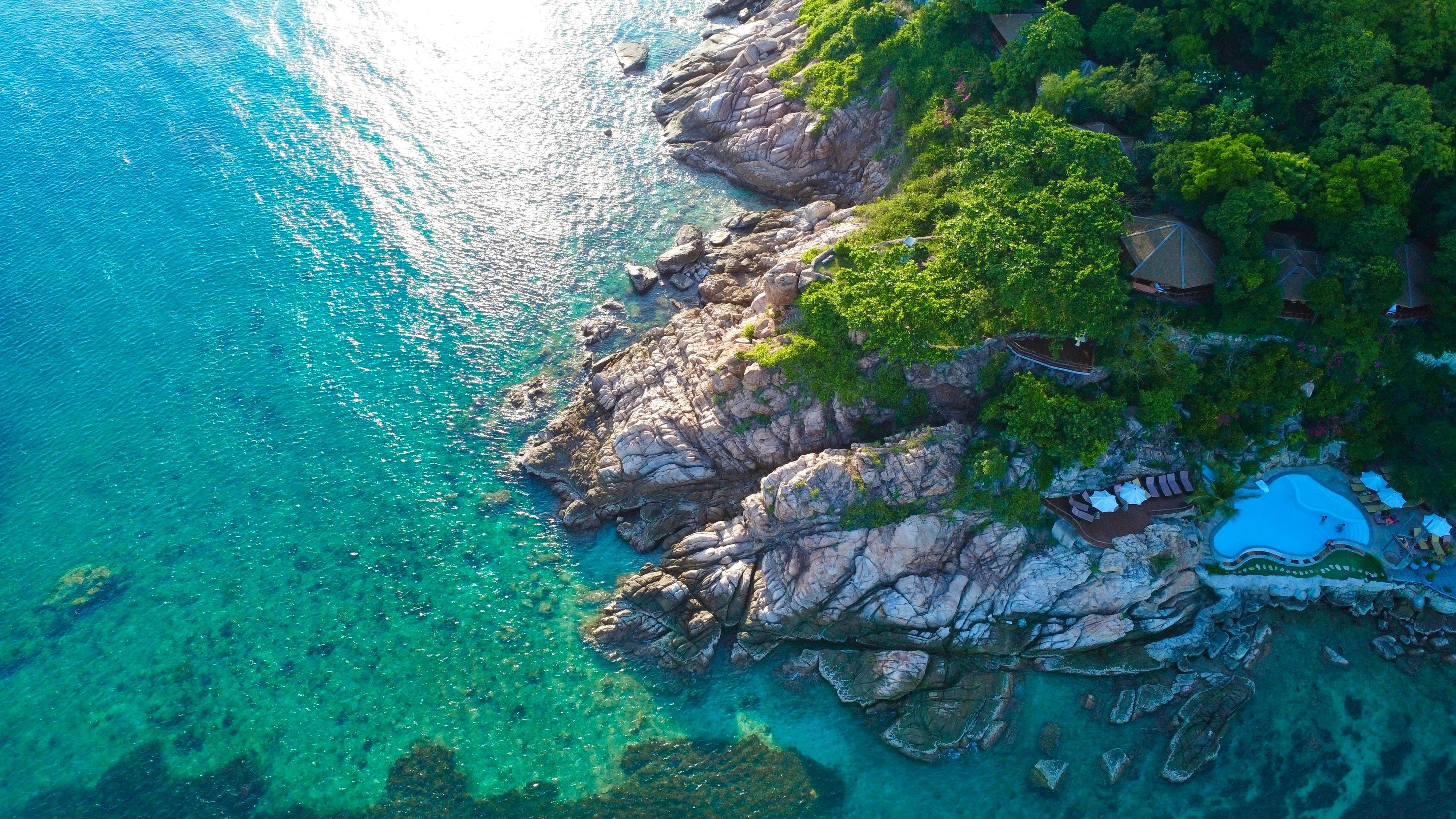 热带海岸线的无人机景观，清澈碧绿的海水和郁郁葱葱的绿色植物