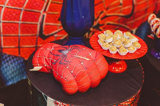 Vibrant Spider-Man themed glove and desserts on a decorative tray for a lively food presentation.