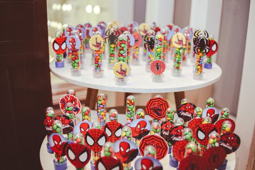 Vibrant Spiderman-themed candy setup on a round table, perfect for celebrations.