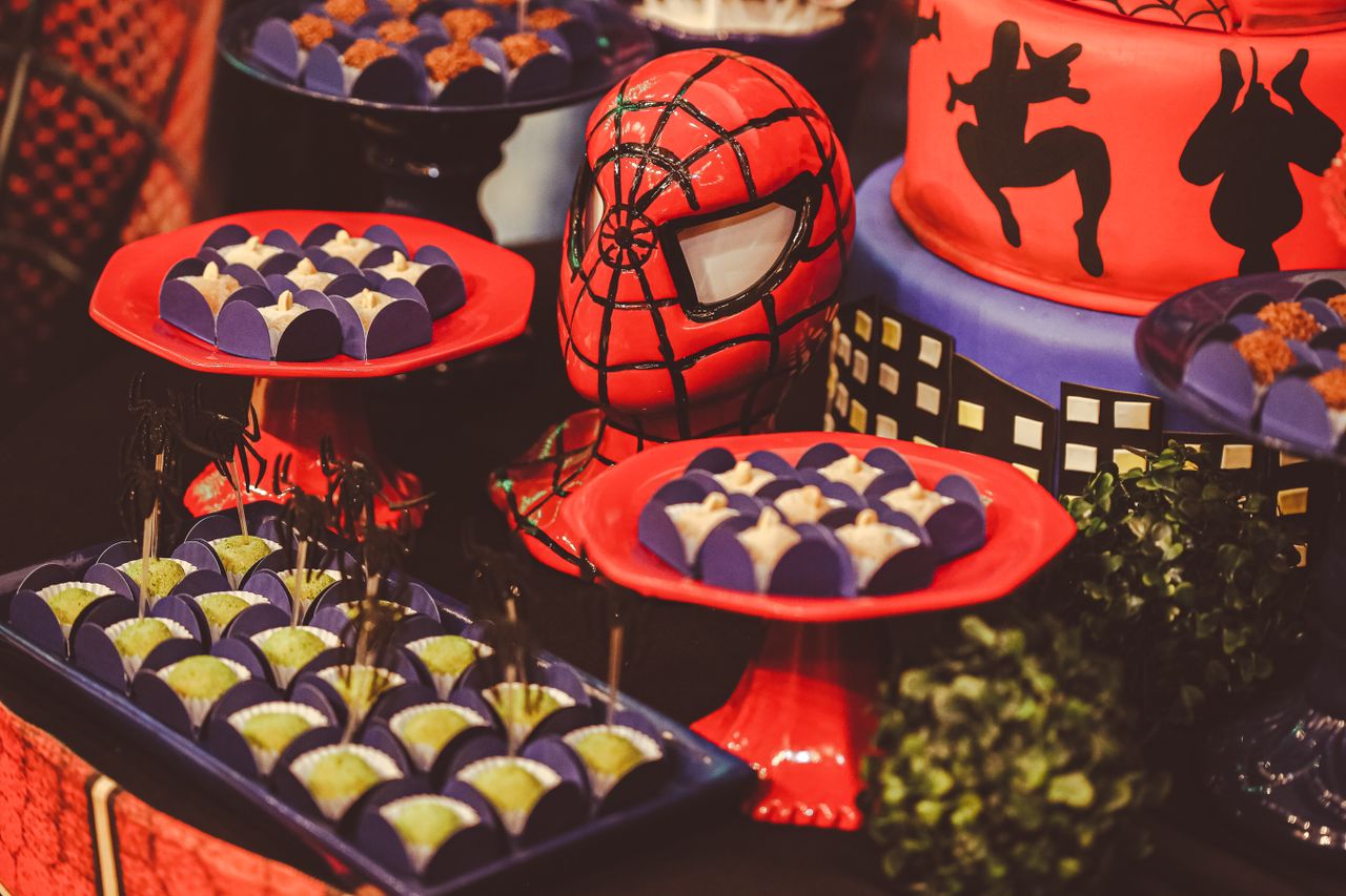 a spider themed birthday party table featuring desserts and a creative