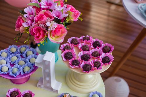 Free Colorful display of chocolates and candies on cake stands with floral decor for a birthday party. Stock Photo