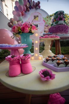 Charming first birthday decor with desserts, balloons, and floral accents in a colorful setting.