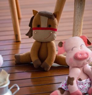 Handmade plush horse and pig toys on a wooden floor — photo by Vidal Balielo Jr. on Pexels