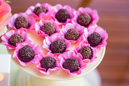 Free Chocolate brigadeiros presented on a pink floral plate. Perfect for dessert tables or sweet snacks. Stock Photo