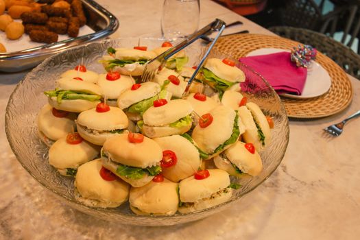 A close-up shot of a delicious mini sandwich platter on a marble table, perfect for gatherings.