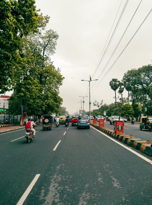 Free Candid shot of a bustling urban street with traffic under a cloudy sky. Stock Photo