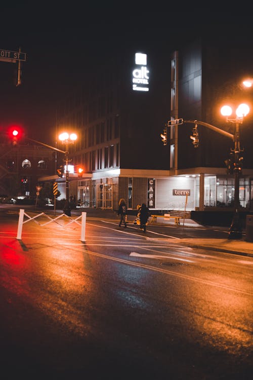 People Walking on Sidewalk during Night Time