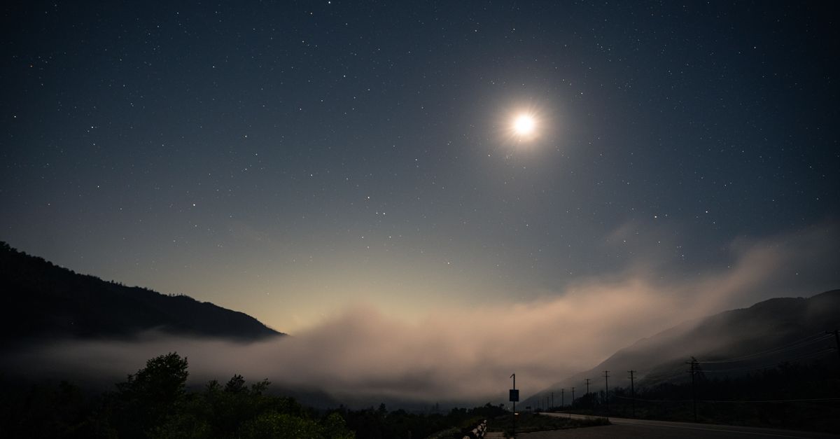 Peaceful night scene of a full moon over a starry sky in Forest Falls, CA.