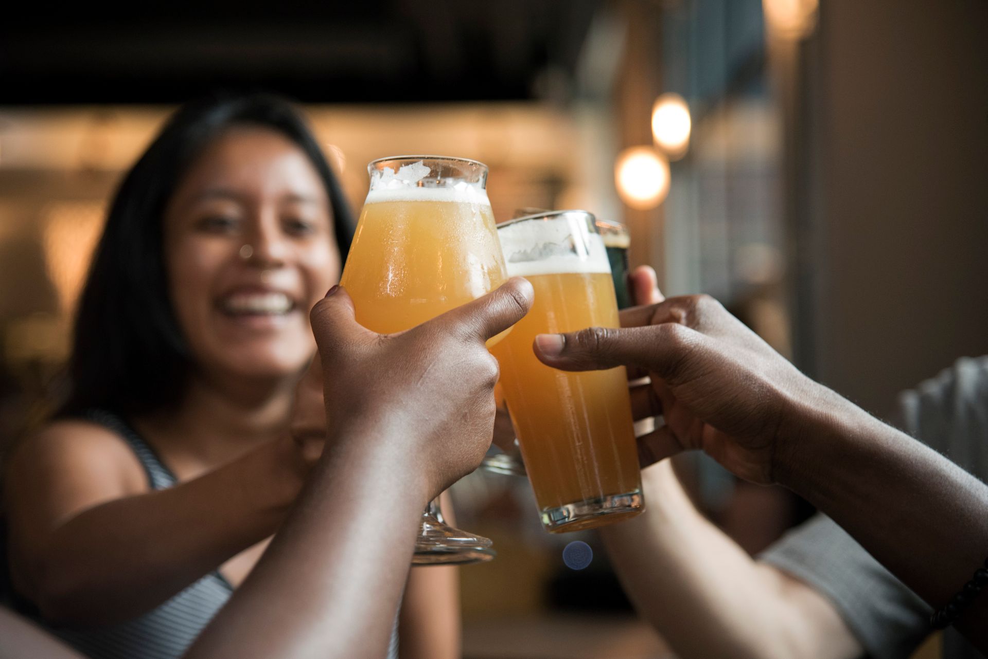 Pessoa segurando cerveja artesanal em ambiente premium de pub moderno com iluminacao quente