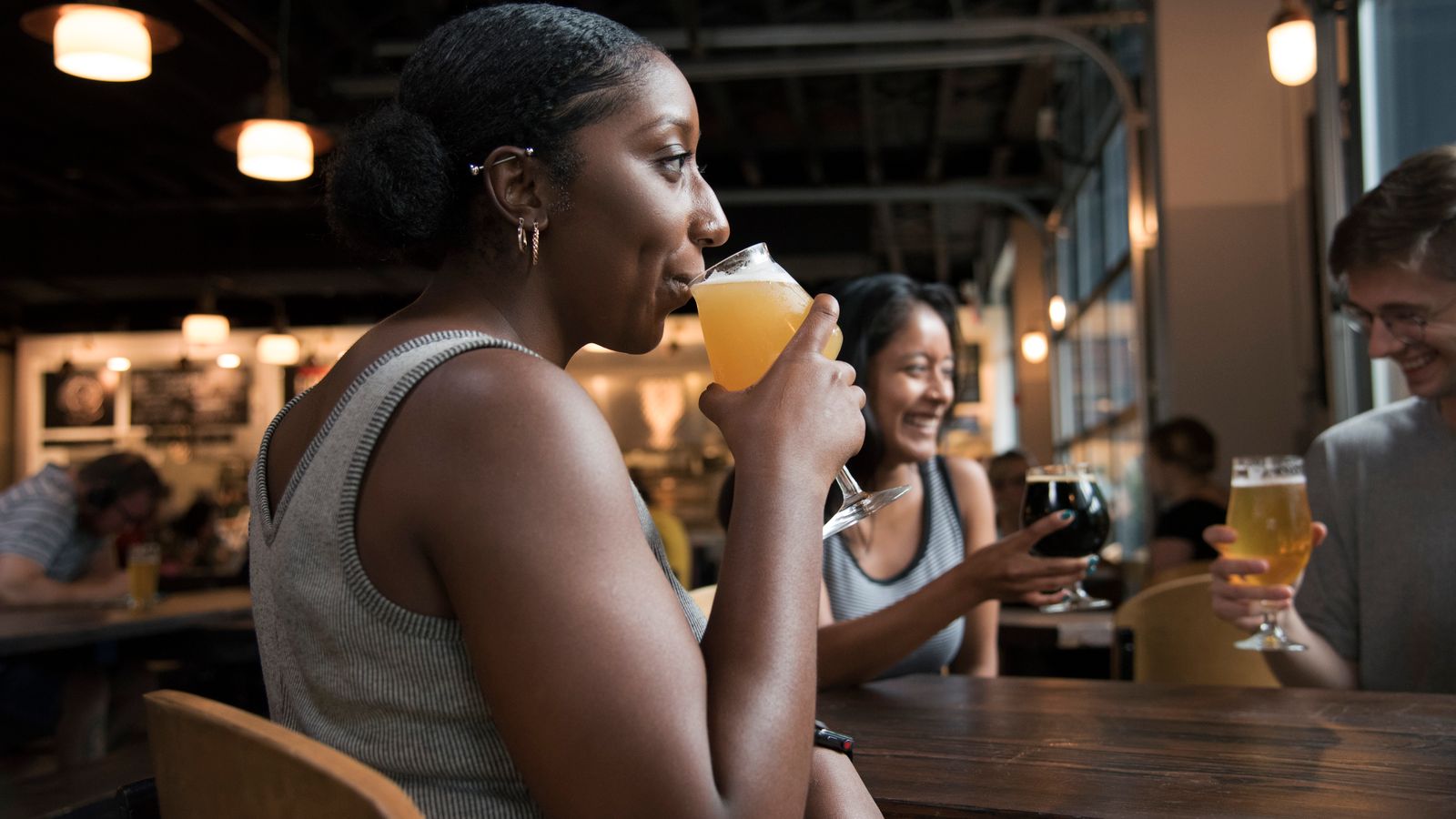 Group of friends having a good time sipping drinks in a cozy bar setting.