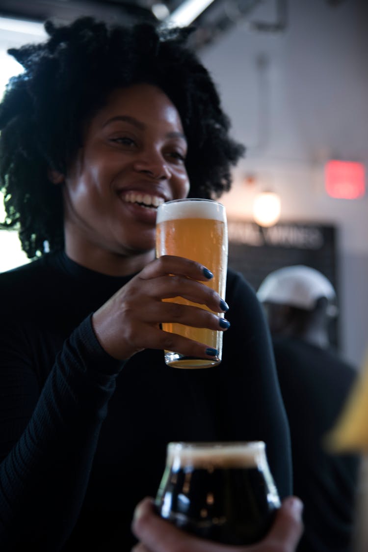 Cheerful Black Woman With Beer In Pub