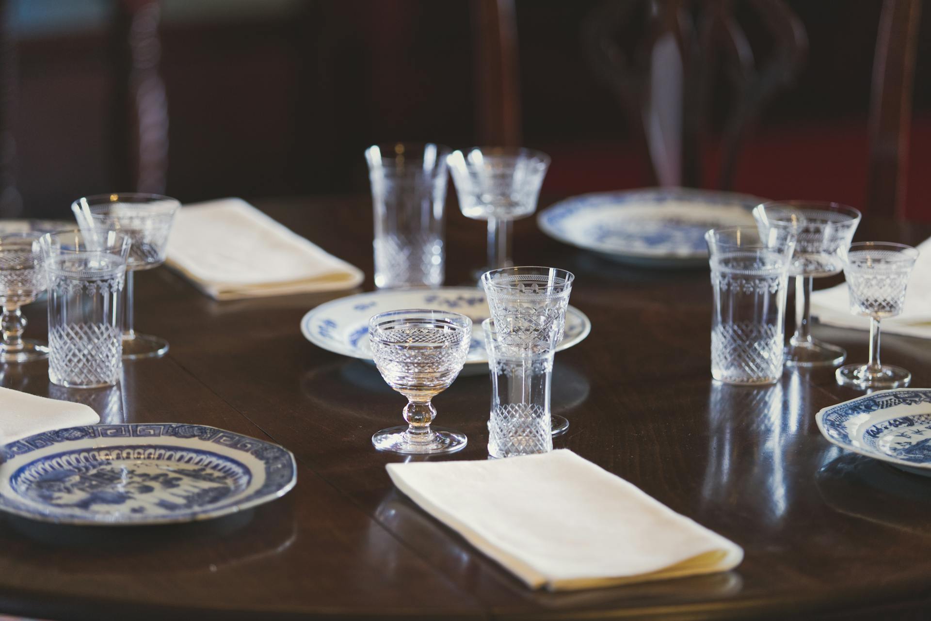 A sophisticated dining table setting with crystal glasses and blue porcelain plates, adding elegance to any occasion.