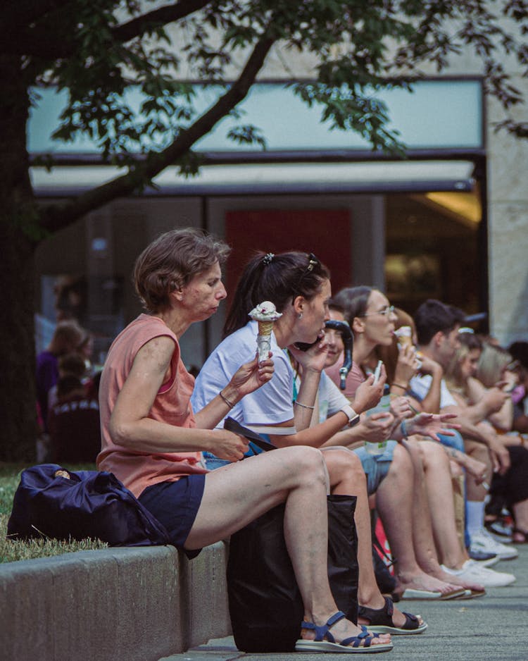 People Sitting Outdoors Eating Ice Cream