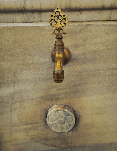 Decorated, Golden Faucet on Wall