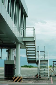 Vertical view of a staircase leading to a jet bridge at a modern airport.