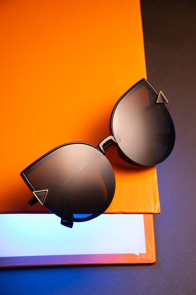 Clear optical frames and sunglasses styled with tropical leaves