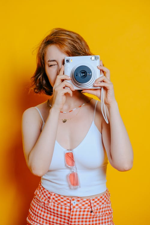 Woman in White Tank Top Holding a Camera