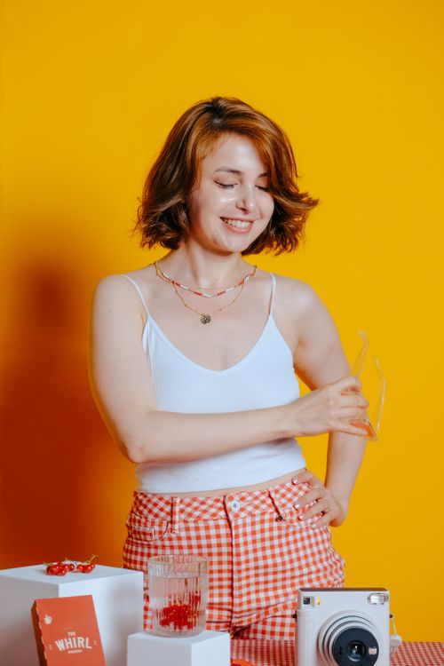 Free Happy woman posing in studio environment with vibrant yellow background, embracing lifestyle elements. Stock Photo