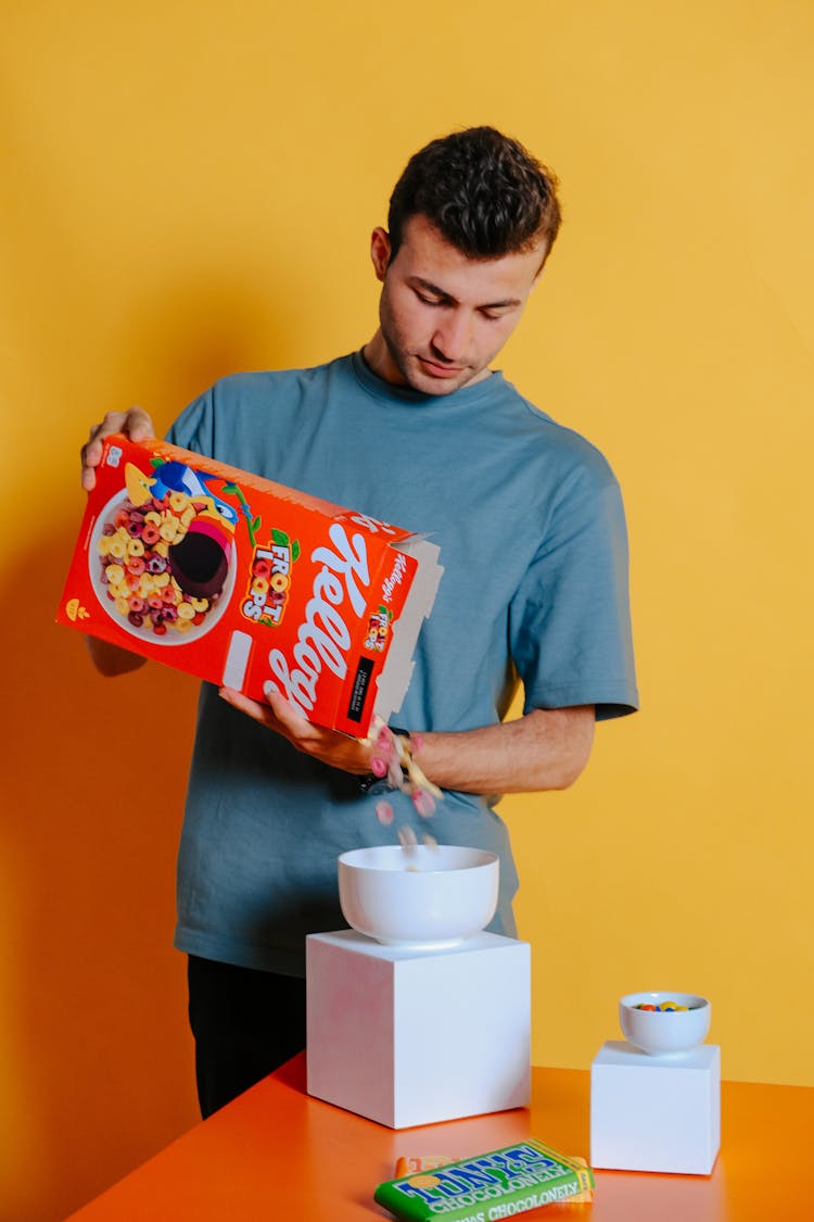 A Man Pouring Cereal In The Bowl