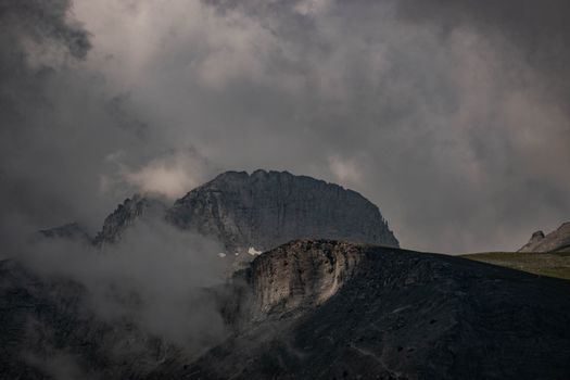 Dramatic view of Mount Olympus shrouded in clouds, showcasing rugged natural beauty.