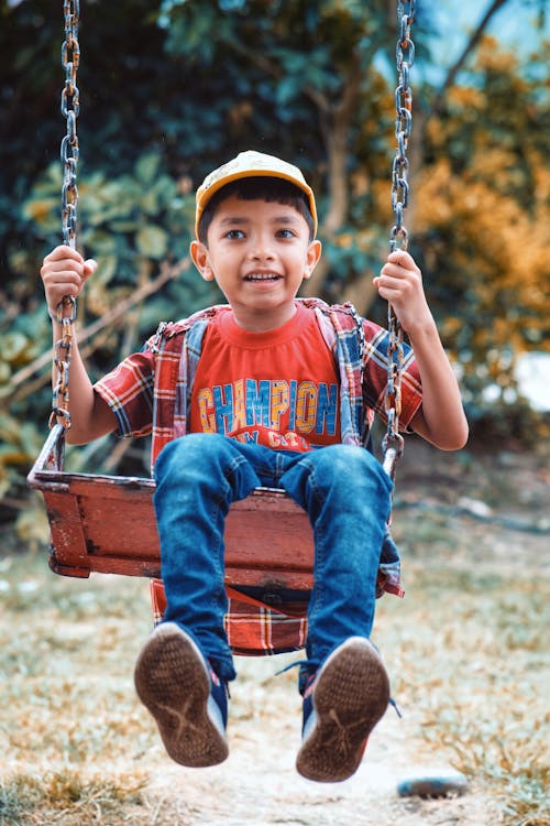 A Young Boy Sitting on the Swing 