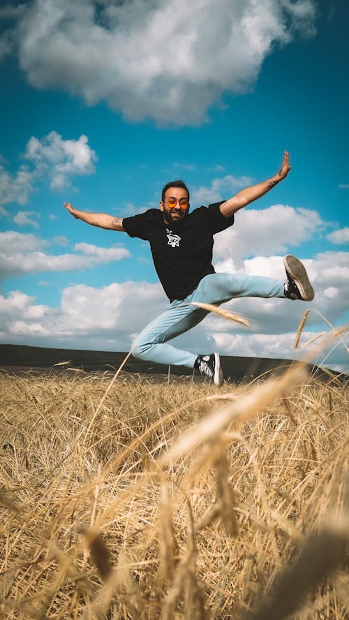 Free A Man Jumping on the Grass Stock Photo