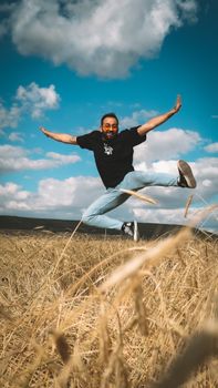 A joyful leap in a vast field under a bright blue sky, exuding freedom.